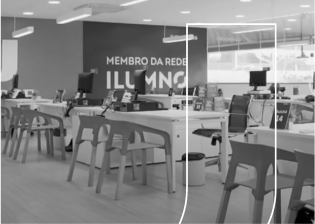 Fotografia da sala de atendimento Unijorge com mesas, cadeiras e computadores