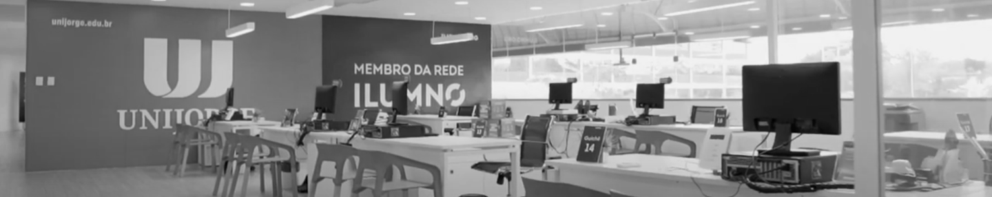 Fotografia da sala de atendimento Unijorge com mesas, cadeiras e computadores